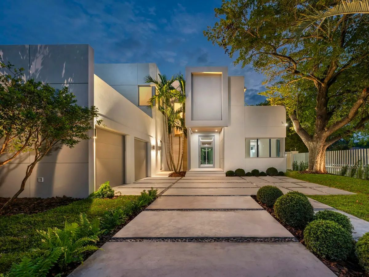 Allée d’entrée éclairée au crépuscule devant une maison contemporaine